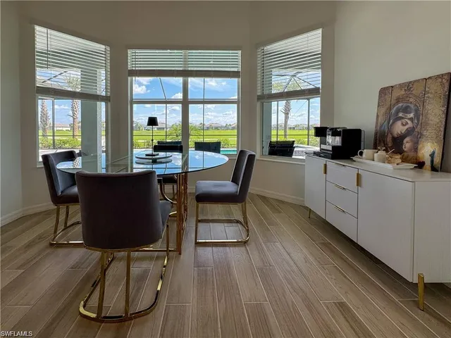 a dining room with wooden floor a glass table and chairs