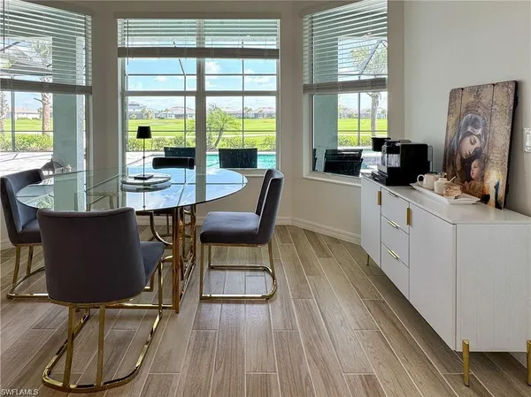 a dining room with wooden floor a glass table and chairs