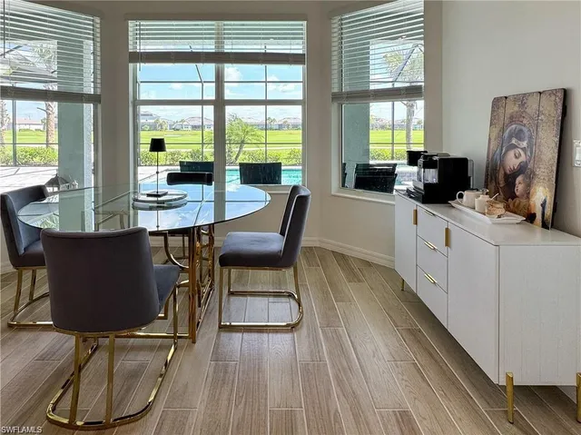 a dining room with wooden floor a glass table and chairs