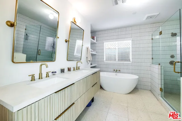 a bathroom with a double vanity sink mirror and bathtub