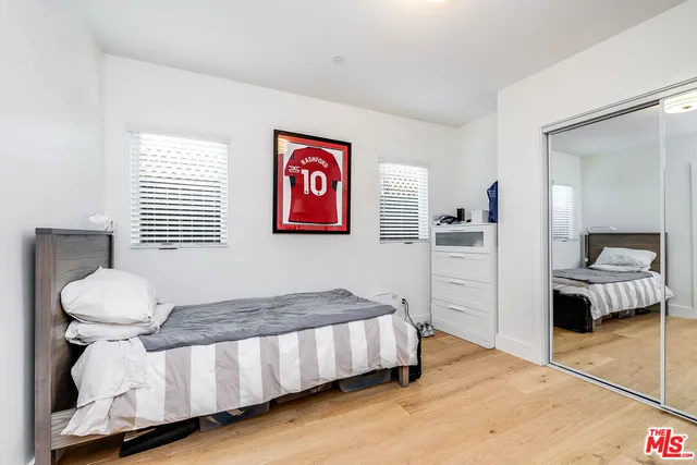 a spacious bedroom with a bed and a view of living room