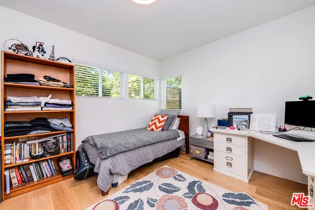 a bedroom with a bed and a book shelf