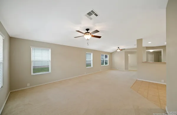 an empty room with a ceiling fan and window