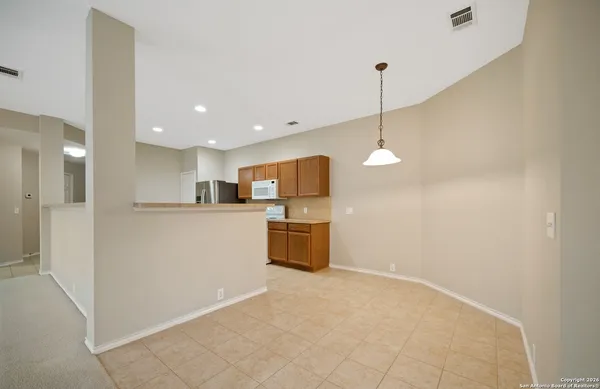 a kitchen with stainless steel appliances granite countertop white cabinets a refrigerator and a sink