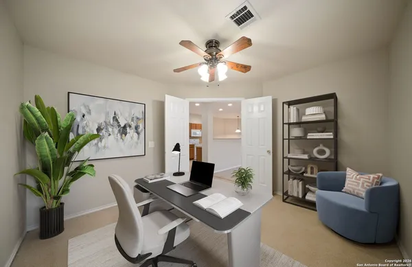 a work room with furniture and a potted plant