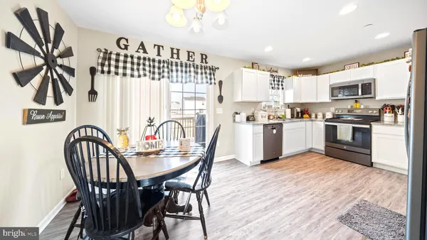 a kitchen with stainless steel appliances a table chairs and a refrigerator