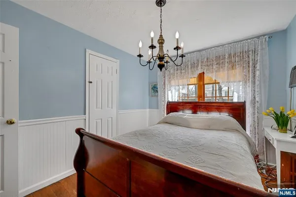a bedroom with a bed and a chandelier