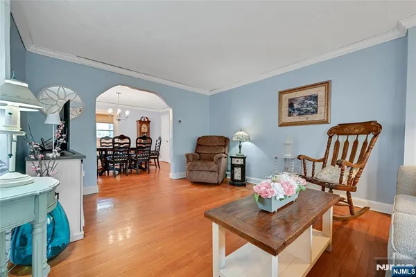 a living room with furniture and a large mirror with wooden floor