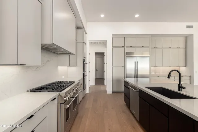 a kitchen with granite countertop a sink stainless steel appliances and cabinets