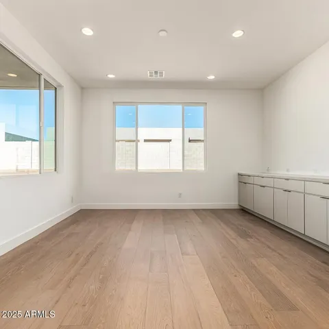 a view of an empty room with a window and wooden floor