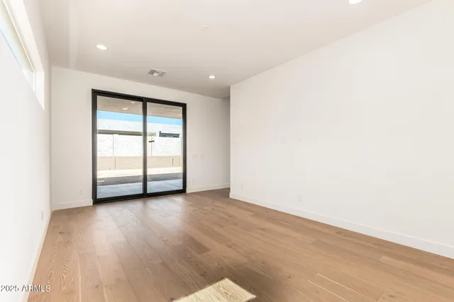 an empty room with wooden floor and closet