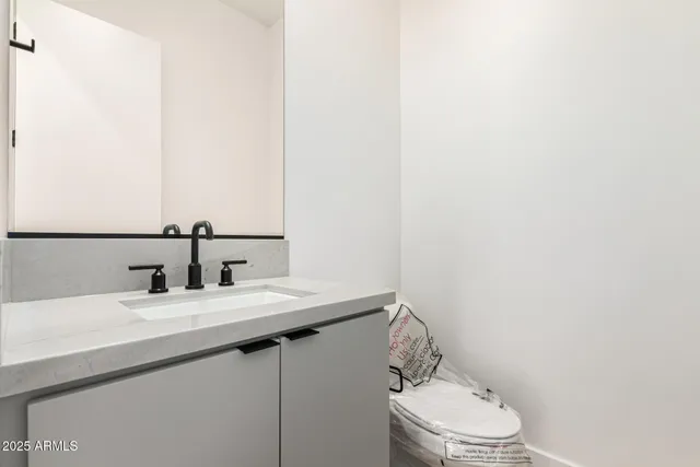 a bathroom with a sink a toilet and mirror