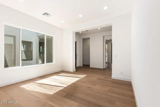 a view of a livingroom with wooden floor and a bathroom
