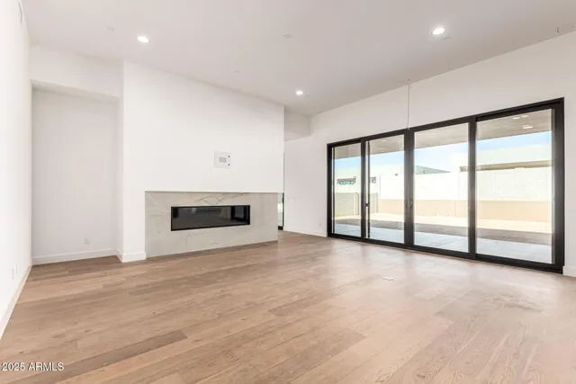 a view of an empty room with a fireplace and a large window