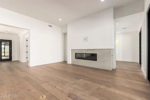 an empty room with wooden floor and fireplace