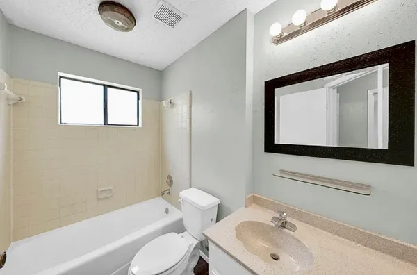 a bathroom with a toilet sink tub and mirror