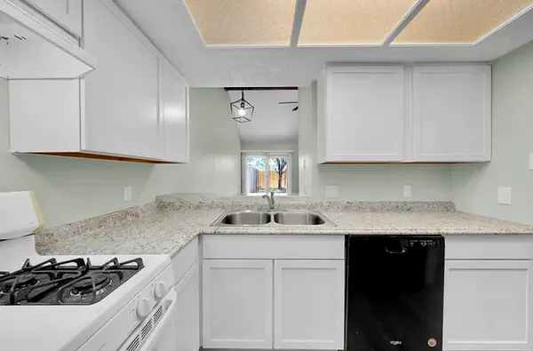 a kitchen with stainless steel appliances granite countertop a sink stove and cabinets