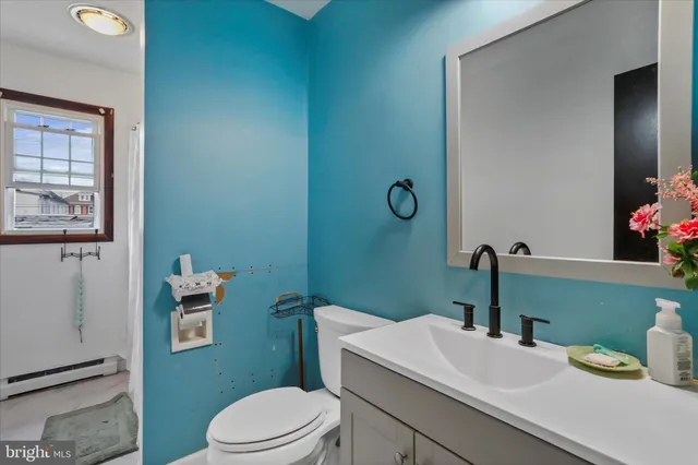 a bathroom with a sink vanity mirror and toilet