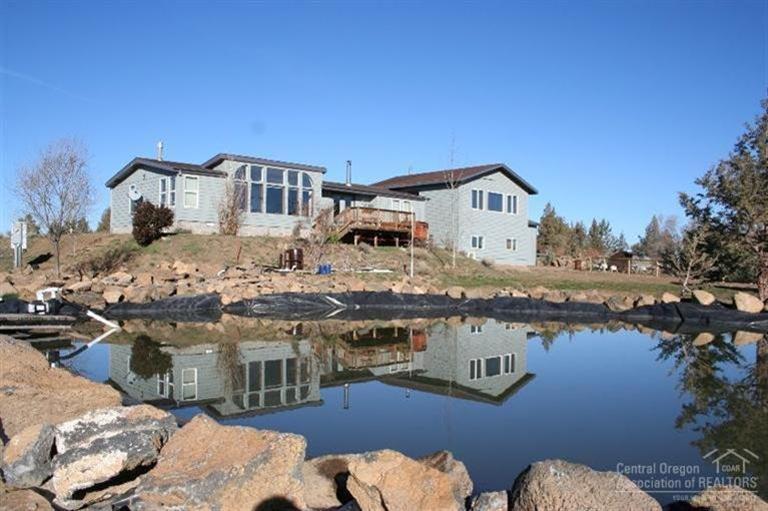 61153 Ropp Lane Bend, OR 97702 - Photo 1 of 25 a front view of a house with lake view and a residential house with swimming pool