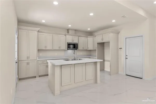 a kitchen with a sink white cabinets and stainless steel appliances