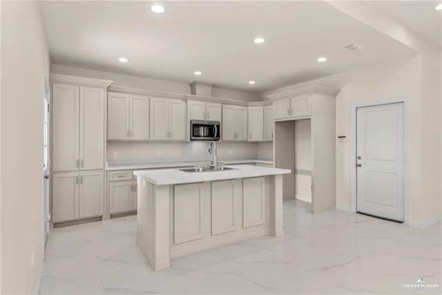 a kitchen with a sink white cabinets and stainless steel appliances