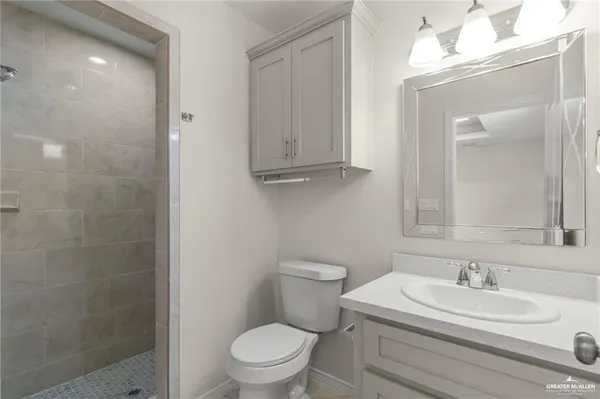 a bathroom with a toilet a sink a mirror and vanity