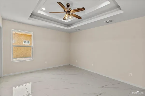 an empty room with a window and a ceiling fan