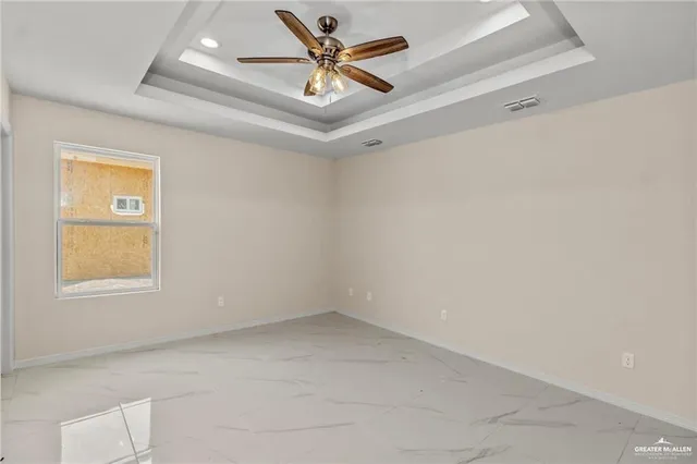 an empty room with a window and a ceiling fan