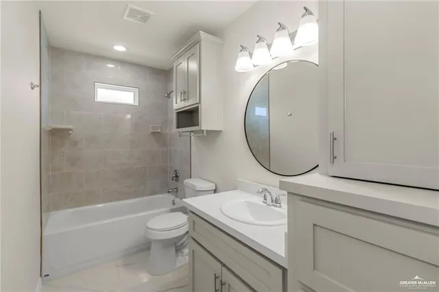 a bathroom with a granite countertop toilet a sink and a mirror