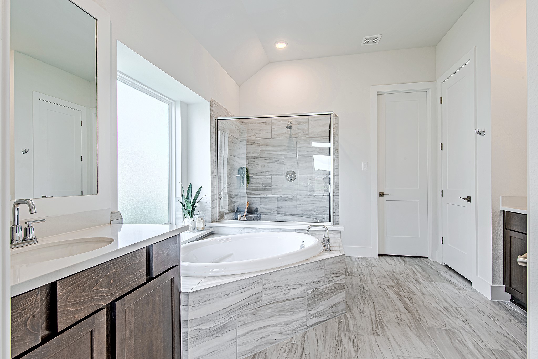 187 Peninsula Point Drive Montgomery, TX 77356 - Photo 14 of 31 Sleek and serene—this primary bath features a soaking tub, glass-enclosed shower, and beautiful tilework that elevates the entire space.