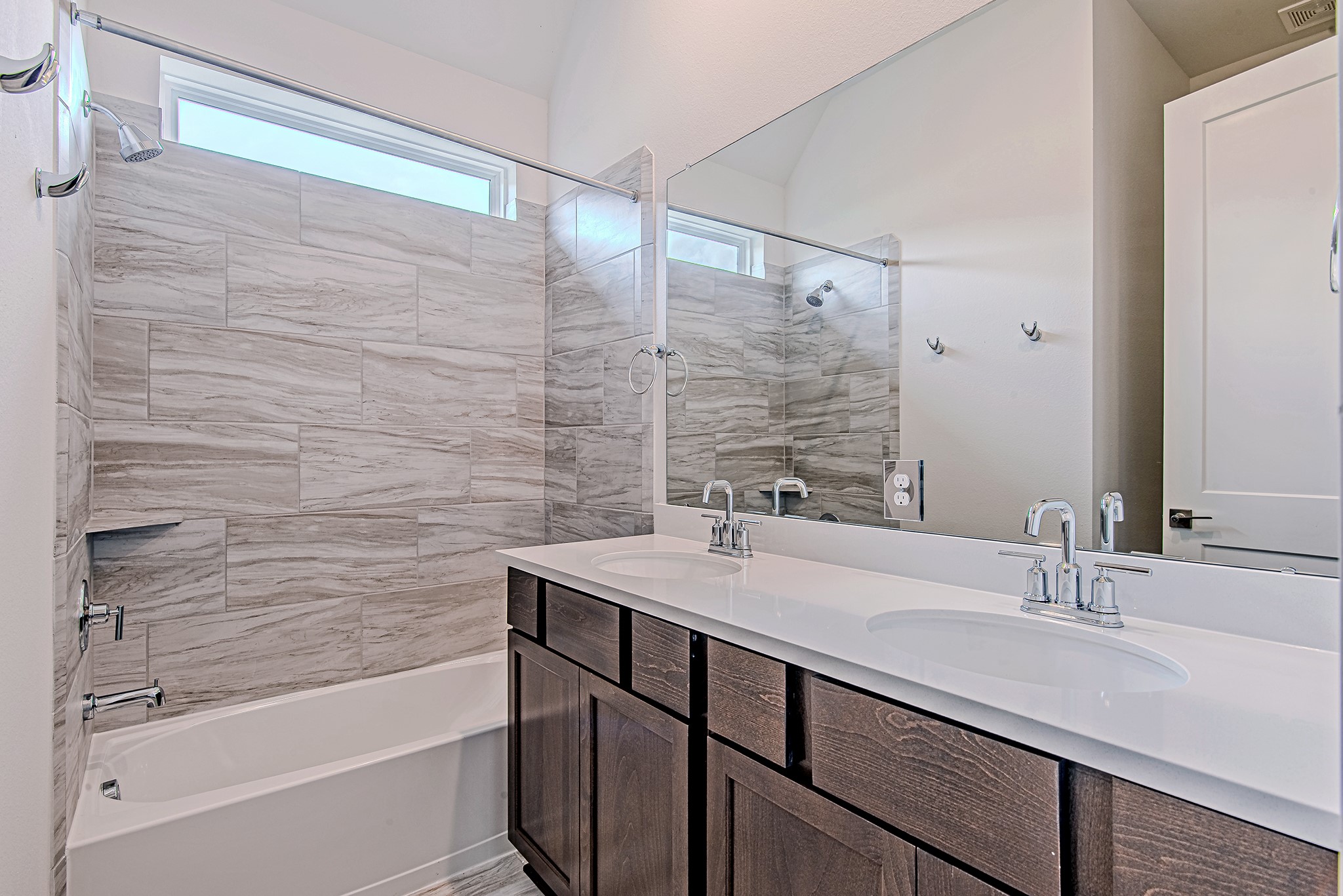 187 Peninsula Point Drive Montgomery, TX 77356 - Photo 22 of 31 This well-appointed guest bath features a double vanity and a tub/shower combo with elevated tile detail—because even your guests deserve the VIP treatment.