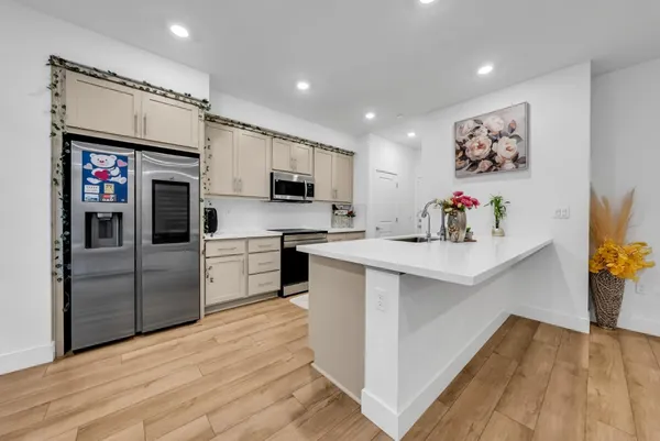 a kitchen with a sink stainless steel appliances and white cabinets