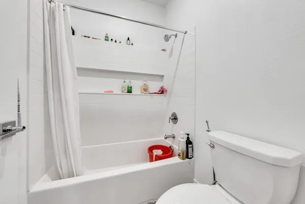a white toilet sitting next to a bath tub
