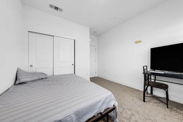a bedroom with a bed and a flat screen tv