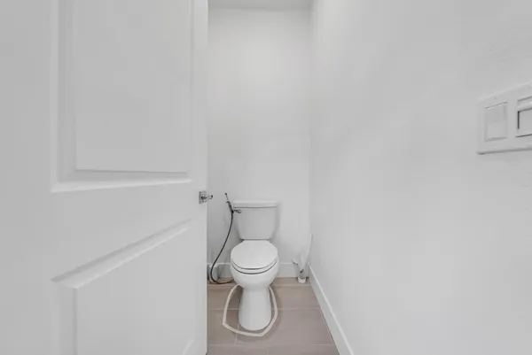 a white toilet sitting next to a white wall