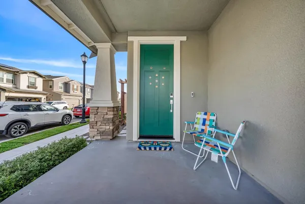 a view of a chair and tables in the back yard of the house