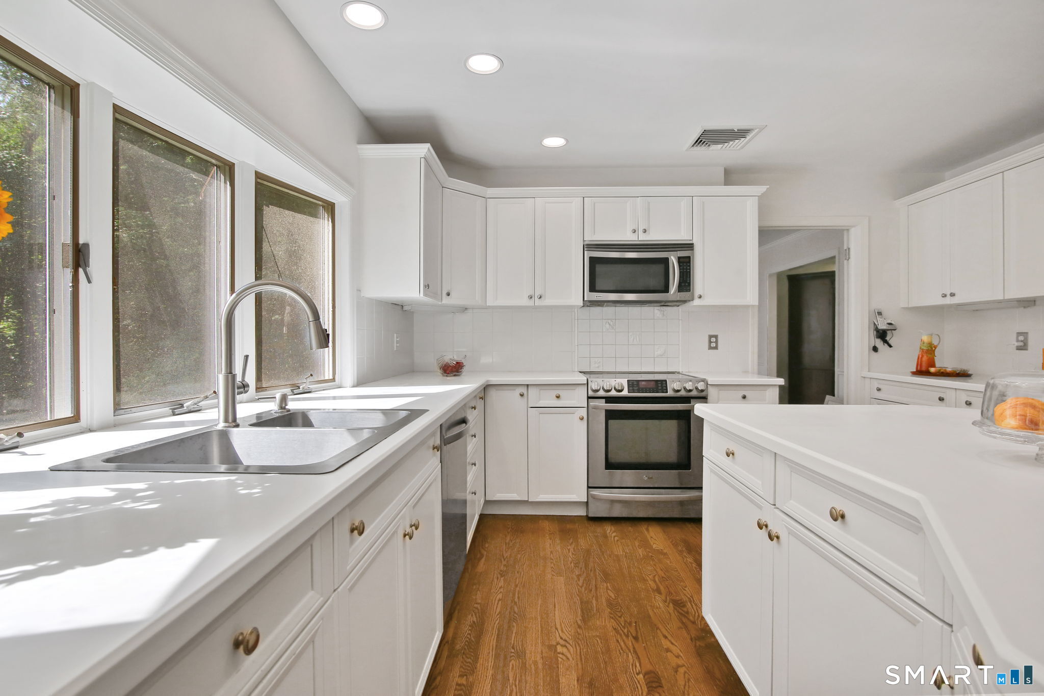 63 Pipers Hill Road Wilton, CT 06897 - Photo 11 of 37 a kitchen with white cabinets and appliances