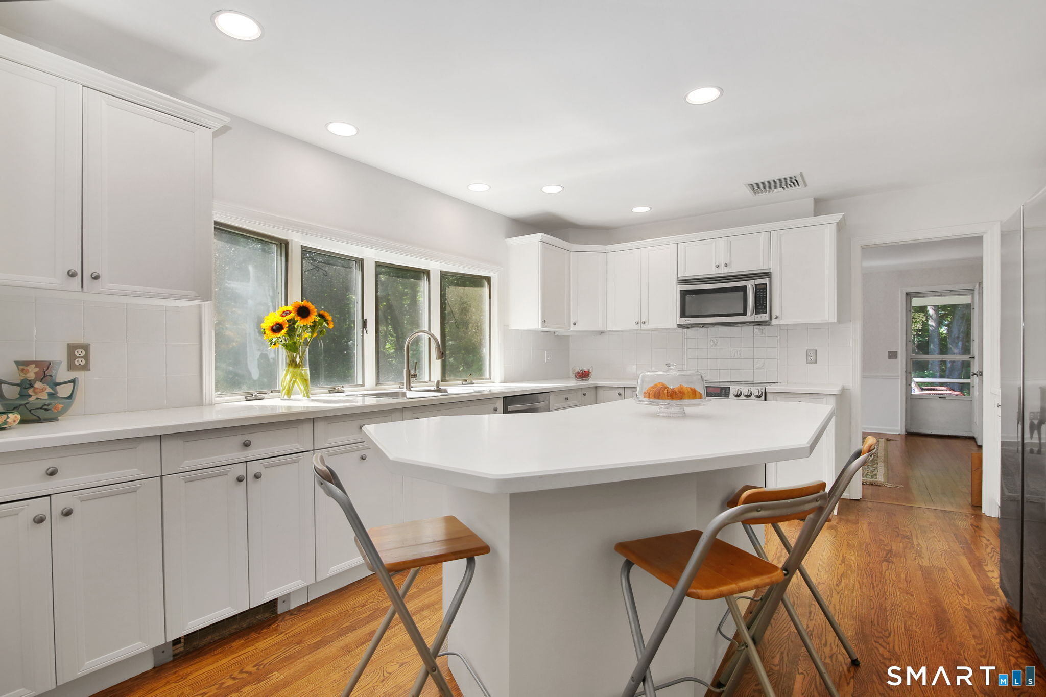63 Pipers Hill Road Wilton, CT 06897 - Photo 13 of 37 a kitchen with stainless steel appliances a sink a stove a refrigerator cabinets and dining table
