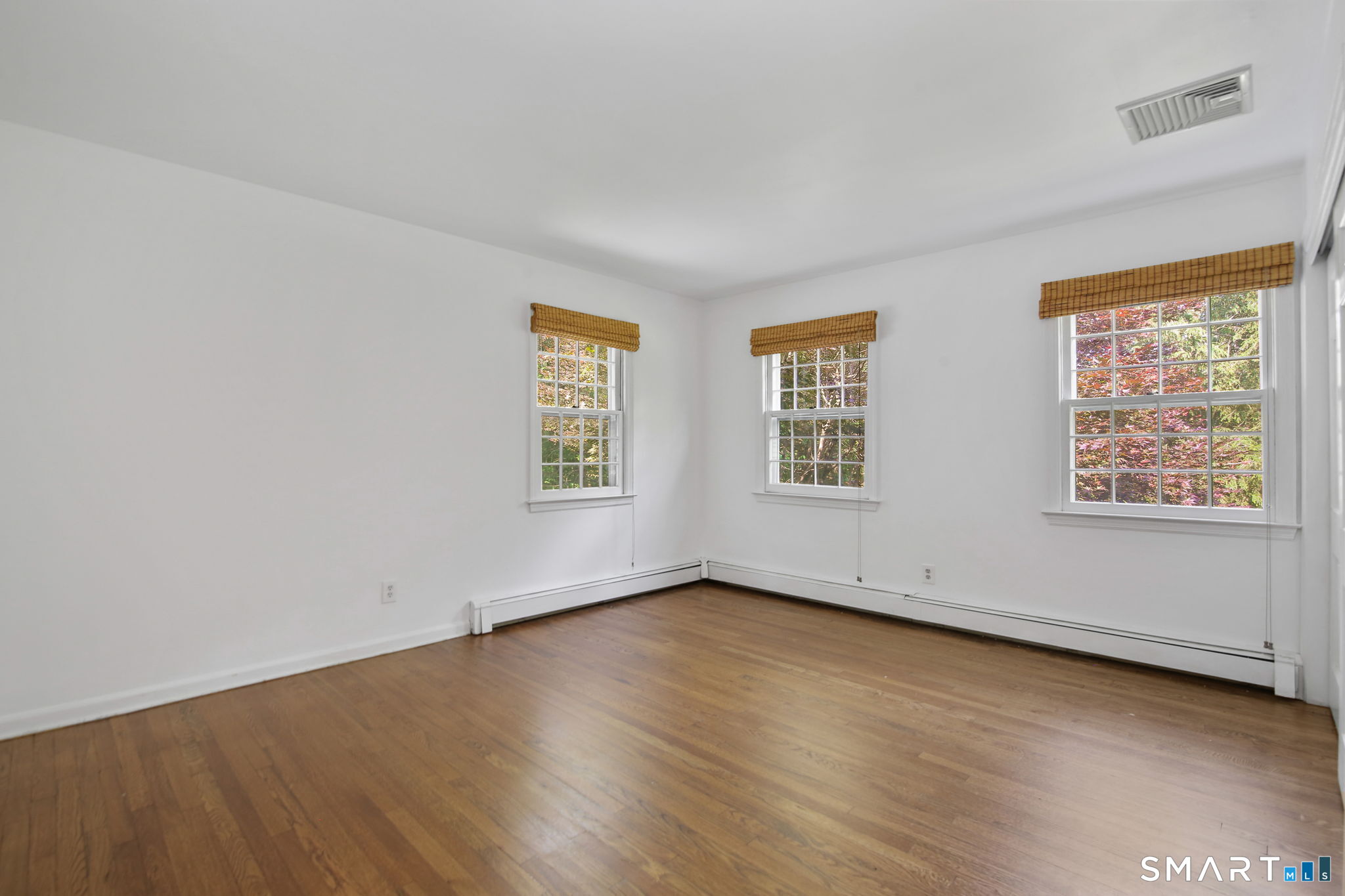 63 Pipers Hill Road Wilton, CT 06897 - Photo 24 of 37 an empty room with wooden floor and windows