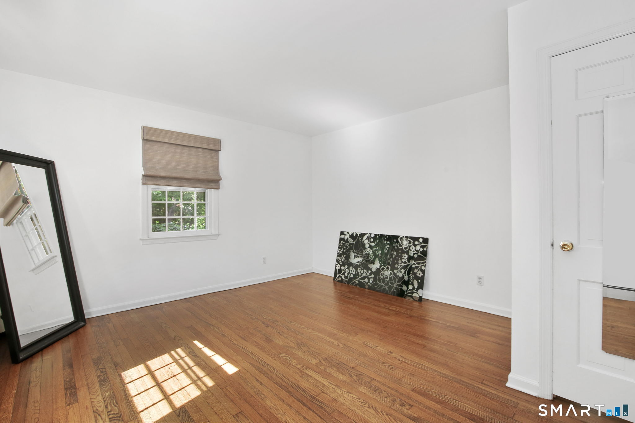 63 Pipers Hill Road Wilton, CT 06897 - Photo 25 of 37 an empty room with wooden floor and windows