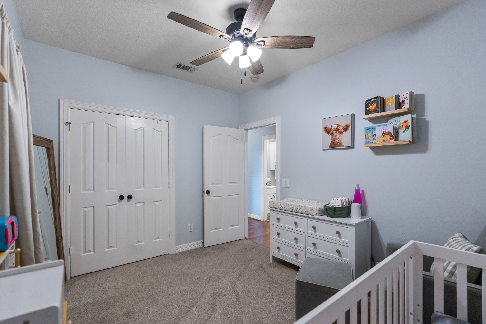 5942 Wildflower Road Sealy, TX 77474 - Photo 22 of 41 a view of a bedroom with baby crib and fan
