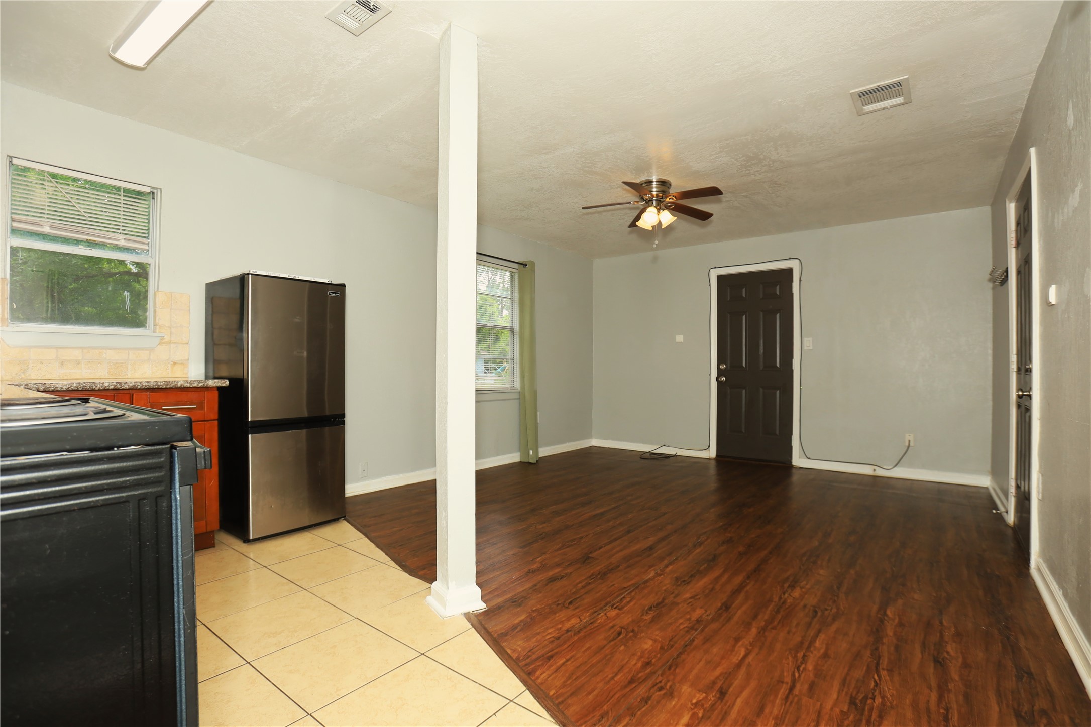 713 South Valderas Street Angleton, TX 77515 - Photo 3 of 10 a view of a kitchen with wooden floor and a refrigerator
