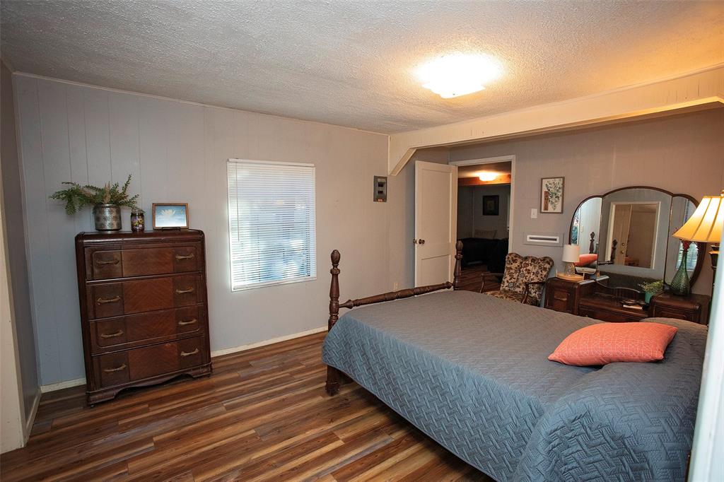 9051 Lacy Road Graford, TX 76449 - Photo 13 of 23 a bedroom with a bed and dresser with mirror