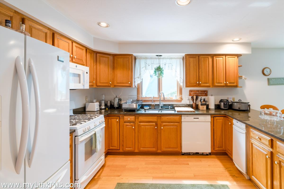 2 Farm Path Road Oak Bluffs, MA 02557 - Photo 11 of 37 a kitchen with stainless steel appliances granite countertop a refrigerator a sink dishwasher a stove with wooden cabinets and floor