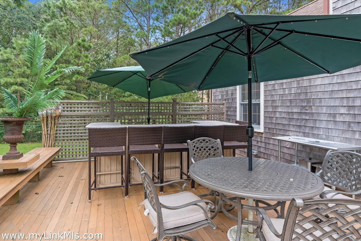 2 Farm Path Road Oak Bluffs, MA 02557 - Photo 13 of 37 a patio with a table and chairs under an umbrella