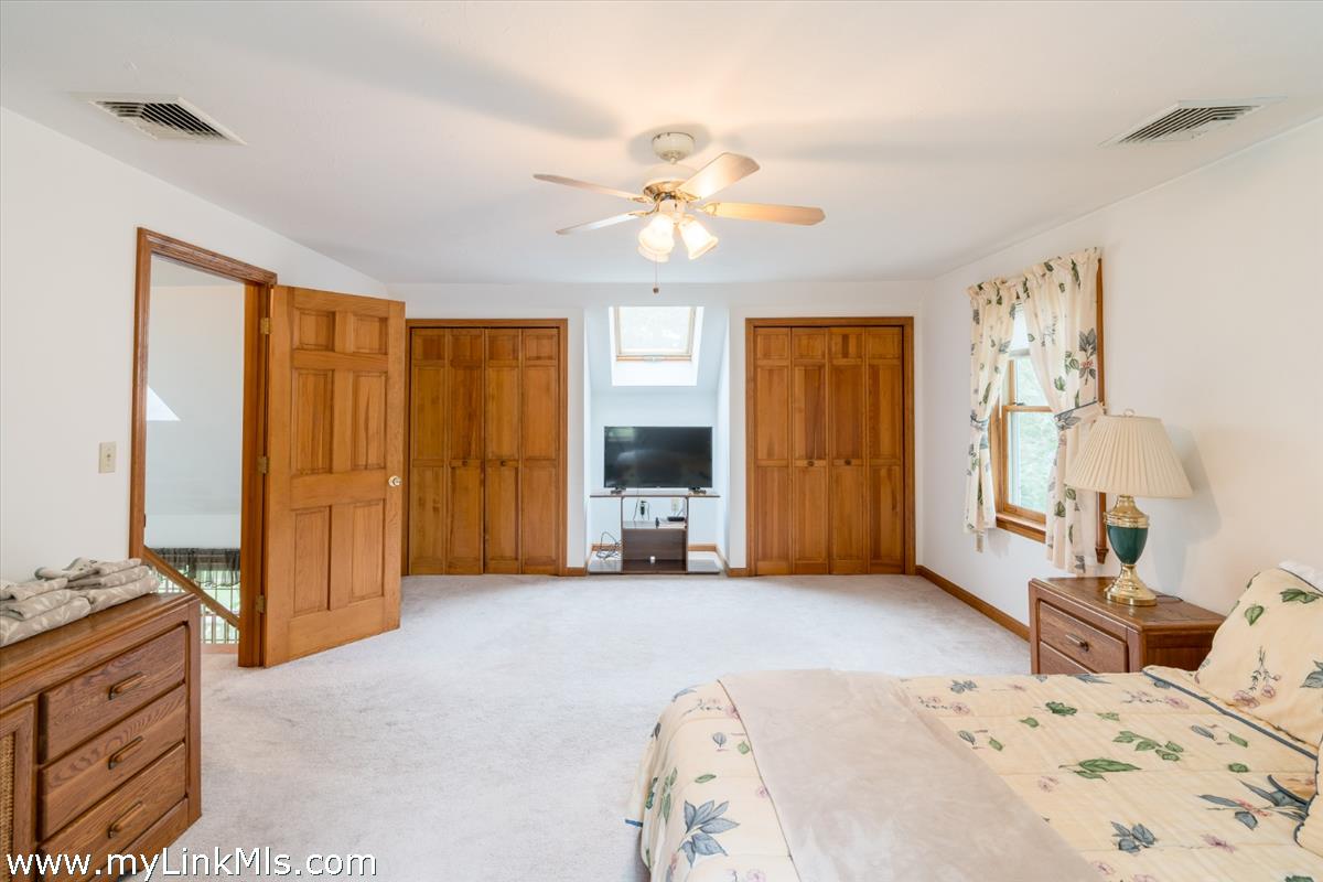 2 Farm Path Road Oak Bluffs, MA 02557 - Photo 24 of 37 a bedroom with a bed and a chandelier