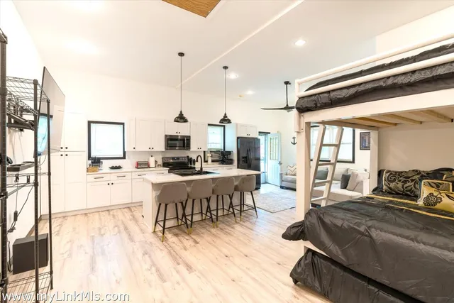 a living room with lots of furniture and view of kitchen