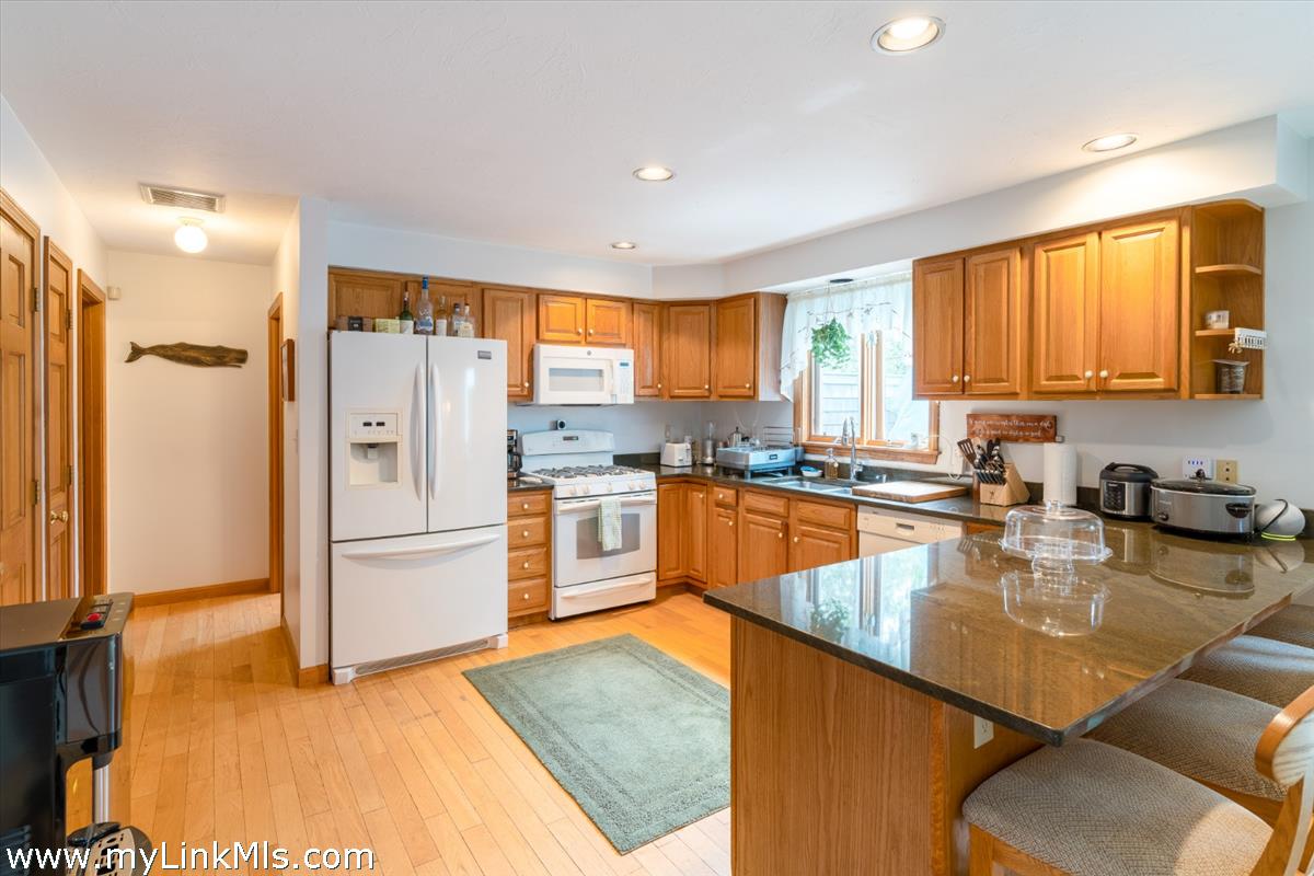2 Farm Path Road Oak Bluffs, MA 02557 - Photo 9 of 37 a kitchen with stainless steel appliances granite countertop a refrigerator a stove and a sink dishwasher with wooden floor