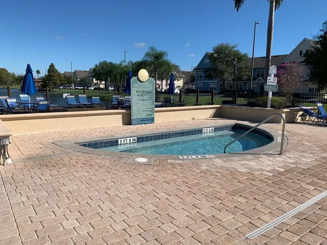 a view of swimming pool with seating space and yard in the back