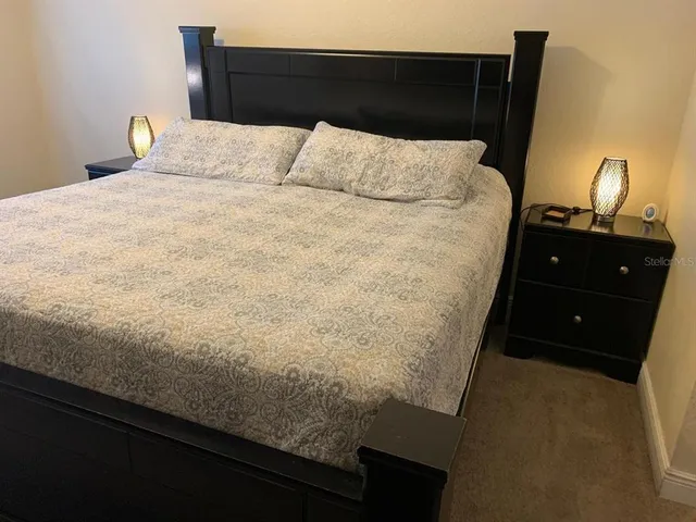 a bed sitting in a bedroom and lamp